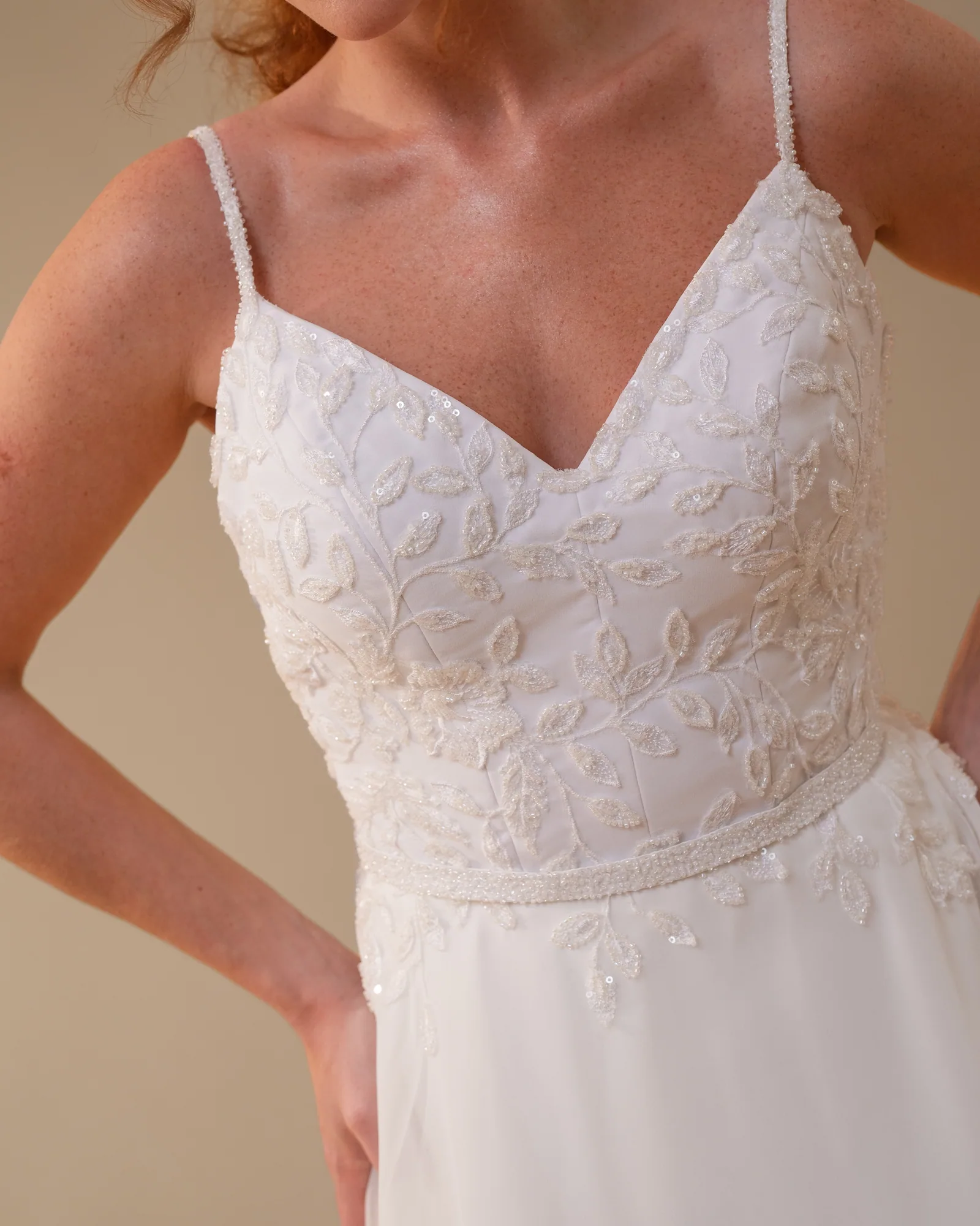 Detalhe do decote em V bordado do vestido Bianca